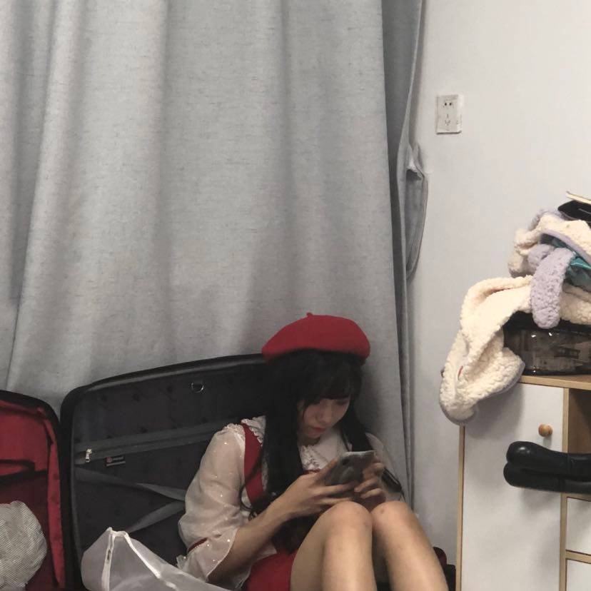 smy sitting in a suitcase on her phone